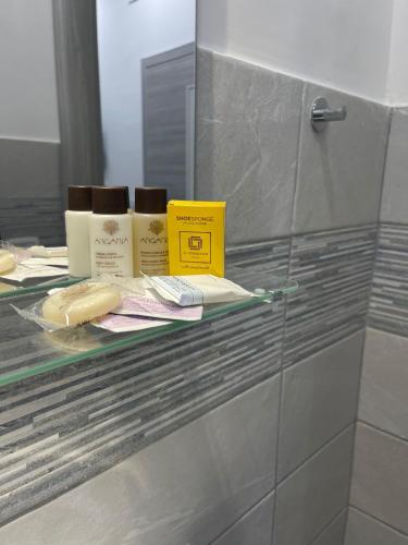 a glass shelf in a bathroom with products on it at B&B La Cumana in Naples