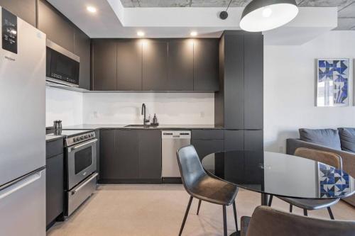 a kitchen with a table and chairs in a room at Initial / Espace M / Centre-ville de Québec in Quebec City