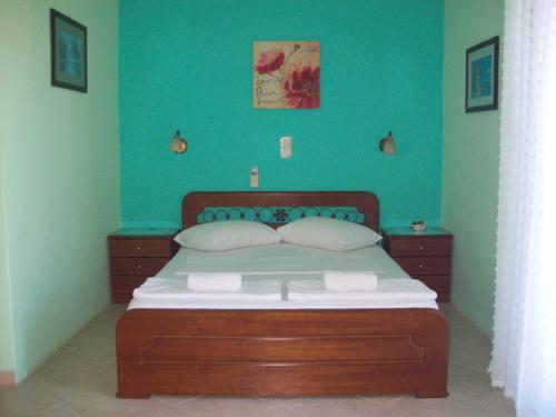 een slaapkamer met een groot bed met blauwe muren bij GARY APARTMENTS in Asos