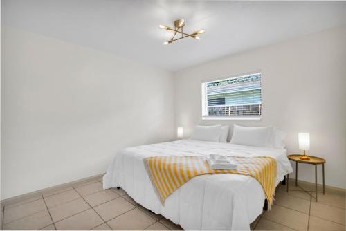 a white bedroom with a bed and a window at LoKal Rental Tropical Florida destination in Fort Lauderdale