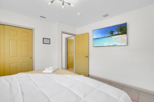 a bedroom with a bed and a picture of a beach at LoKal Rental Tropical Florida destination in Fort Lauderdale