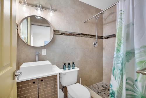 a bathroom with a toilet and a sink and a mirror at LoKal Rental Tropical Florida destination in Fort Lauderdale
