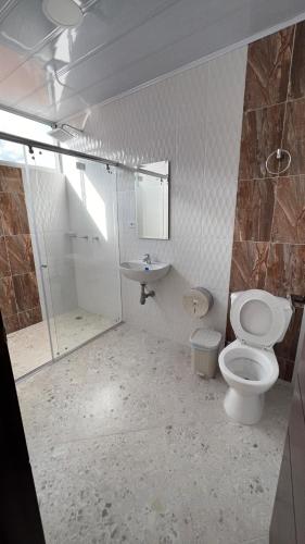 a bathroom with a toilet and a sink at Hospedaje Lycaste in Tibasosa