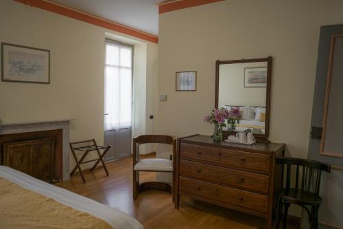 a bedroom with a bed and a dresser and a mirror at Albergo Real Castello in Verduno