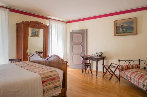 a bedroom with a bed and a table and a chair at Albergo Real Castello in Verduno