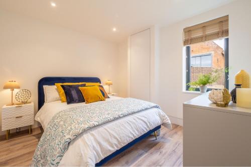 a white bedroom with a bed and a window at 1 Long Barn in Sotherton