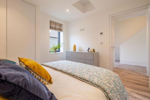 a bedroom with a bed with yellow pillows and a window at 1 Long Barn in Sotherton