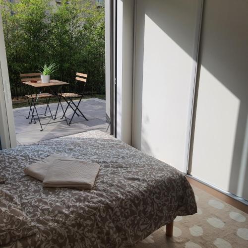 - une chambre avec un lit et une terrasse avec une table dans l'établissement Jolie suite parentale, chambre et salle d'eau, avec son coin de verdure à 5 minutes à pied du centre ville, à Bordeaux