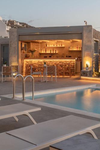 a house with a swimming pool and a bar at Sea Wind Villas and Suites in Tourlos