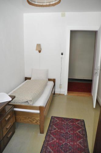 a bedroom with a bed and a door with a rug at Hostel Engelberg "mein Trail Hostel" in Engelberg