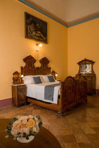 a bedroom with a bed and a table with flowers at Albergo Real Castello in Verduno