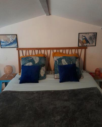 um quarto com uma cama com almofadas azuis em Le Stud' à Saint Pierre d'Oléron ! em Saint-Pierre-dʼOléron