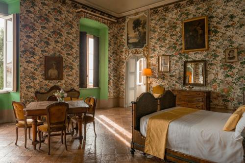 una camera con letto, tavolo e sedie di Albergo Real Castello a Verduno