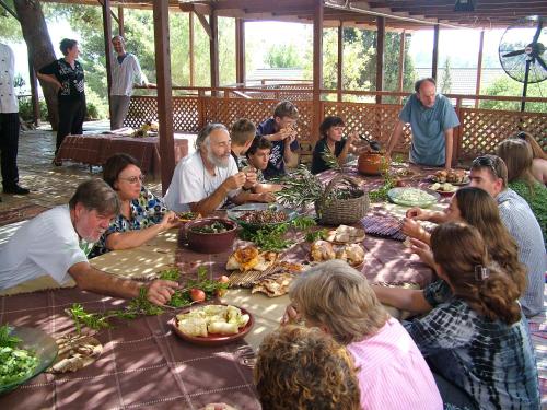 a group of people sitting around a table eating food at Logos hotel in Yad Hashmona in Yad Hashmona