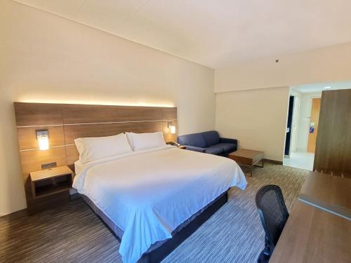 a hotel room with a large bed and a chair at Holiday Inn Express Edgewood-Aberdeen-Bel Air in Edgewood
