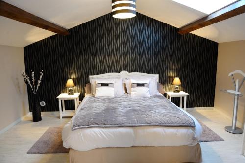 モンブリゾンにあるChambre d'Hôtes des Lysの黒い壁のベッドルーム1室(大型ベッド1台付)