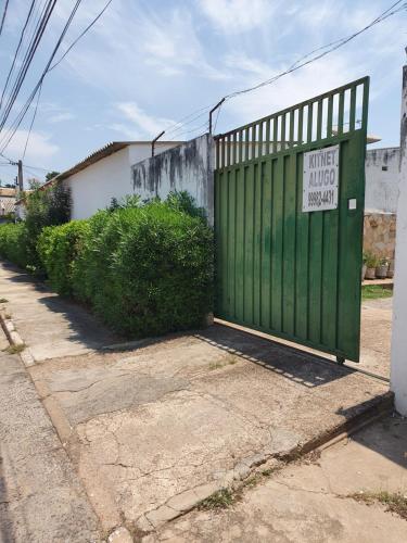 een groene poort met een bord naast een straat bij Suíte 10 Privativa e Aconchegante in Cuiabá