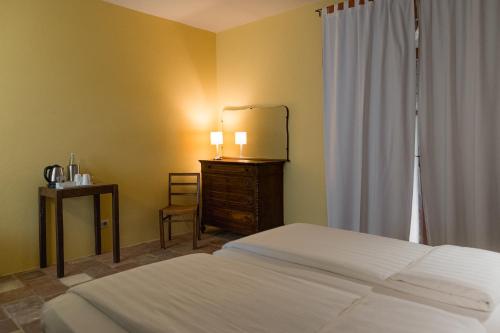a bedroom with a bed and a dresser and a mirror at Albergo Real Castello in Verduno