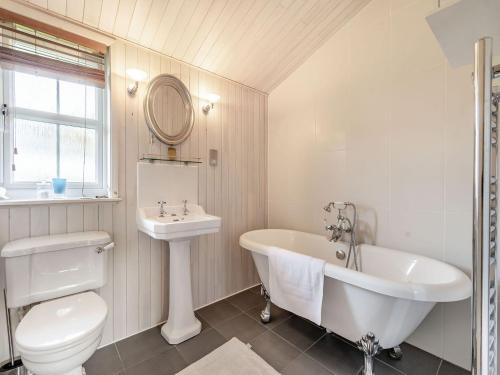 a bathroom with a tub and a toilet and a sink at Beech Tree Lodge in Willington