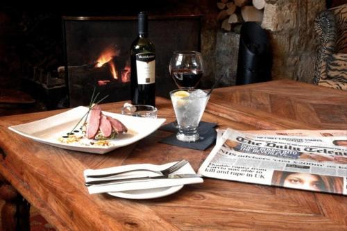 a table with a plate of food and a glass of wine at Redesdale Arms Hotel in Moreton in Marsh