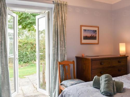 - une chambre avec un lit et une porte coulissante en verre dans l'établissement Farnley Ridge, à Durham