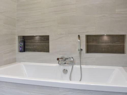 a white bath tub with a faucet in a bathroom at Farnley Ridge in Durham