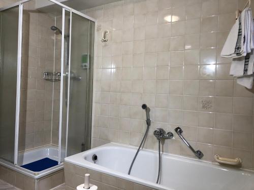 a bathroom with a shower and a bath tub with a shower at Ferienwohnung Familie Hinrichs in Dorn-Dürkheim