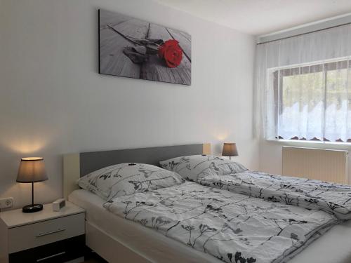 ein Schlafzimmer mit einem Bett und einem Bild an der Wand in der Unterkunft Ferienwohnung Familie Hinrichs in Dorn-Dürkheim