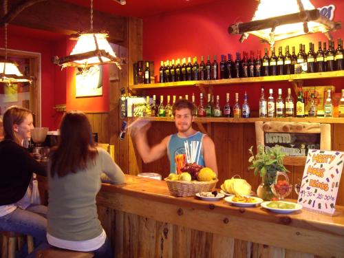 a woman sitting at a counter with a bunch of bottles of wine at Marcopolo Inn Hostel Bariloche in San Carlos de Bariloche