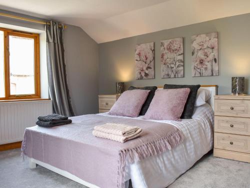 a bedroom with a white bed with pink pillows at Grange Court in Cliburn