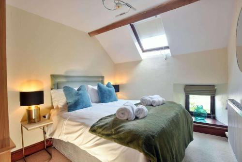 1 dormitorio con 1 cama con toallas en Critchlow Cottage en Buxton