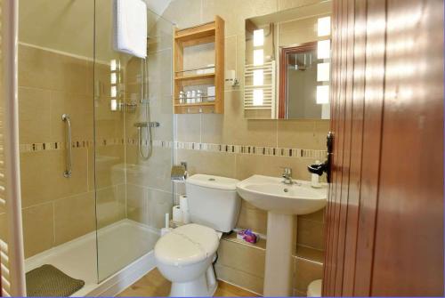 y baño con aseo, lavabo y ducha. en Critchlow Cottage en Buxton