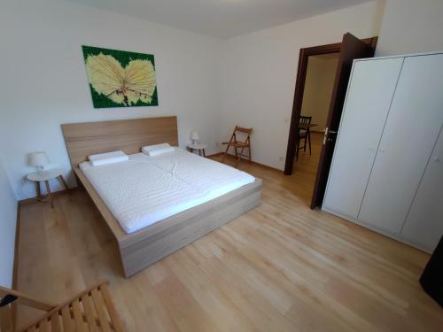 1 dormitorio con 1 cama y suelo de madera en Appartamento vacanza a Sementina, en Sementina