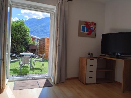 a living room with a sliding glass door with a television at Appartamento vacanza a Sementina in Sementina