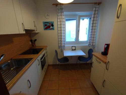 eine Küche mit einer Spüle sowie einem Tisch und Stühlen in der Unterkunft Appartamento vacanza a Sementina in Sementina