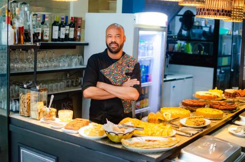 a man standing in front of a buffet of food at Pousada e Hostel Chez Marianne in Salvador