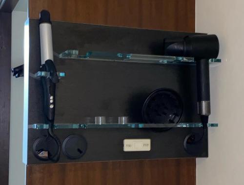 a glass shelf with a hair dryer and a camera at Roppongi Plaza Hotel in Tokyo