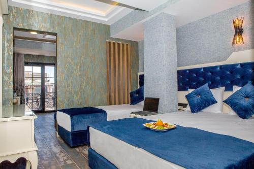 a hotel room with two beds with blue pillows at THE LEA HOTELS & SUITE in Didim