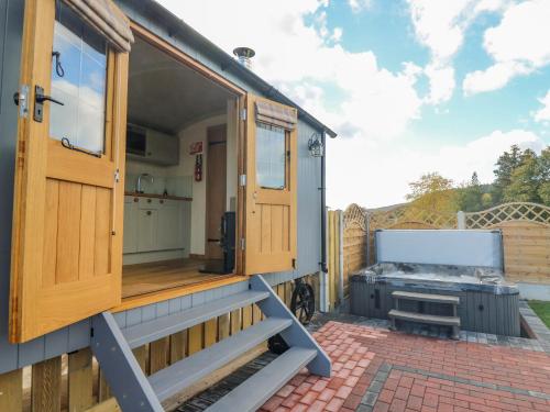 a tiny house with a grill on a patio at Poppy in Rhayader