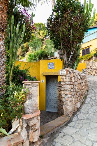 a yellow building with a door in a stone wall at Aeneas' Landing Resort in Gaeta