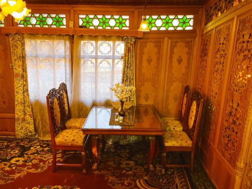 a dining room with a table and chairs and a window at The Heritage Gemini Group of Houseboat in Srinagar