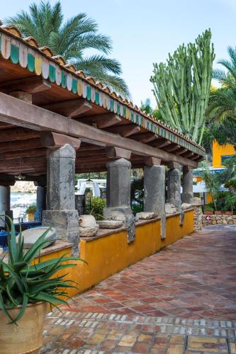a covered walkway in a resort with palm trees at Aeneas' Landing Resort in Gaeta