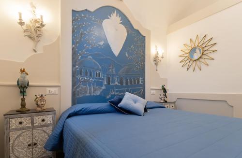 a bedroom with a blue bed with a painting on the wall at Il Moresco Catania in Catania
