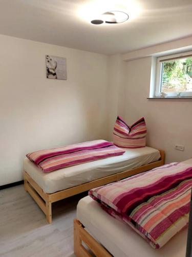 two twin beds in a room with a window at Ferienwohnung Küstenanker in Nienhagen