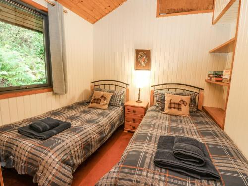 a bedroom with two beds and a window at Firbush Lodge in Killin