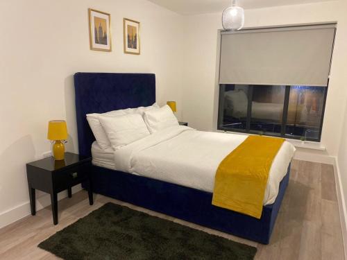 um quarto com uma cama grande e uma janela em Stylish Birmingham City Centre Apartment em Birmingham