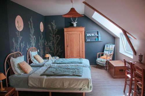 a bedroom with two beds and an attic at Les jardins de Nanine in Lapleau