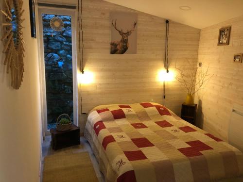 una camera da letto con un letto con una trapunta sopra di Le Cottage du Vieux Moulin a Ravilloles