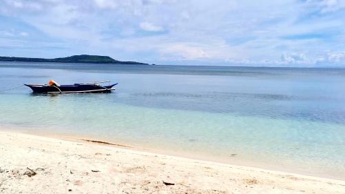 a boat sitting in the water on a beach at BEACH FRONT WHITE HOUSE VILLA in Maria