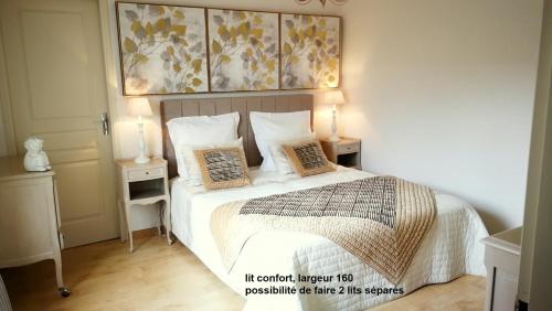 a bedroom with a bed with two night stands and two lamps at Charme Le Cadran Solaire classé 4* in Sancey-le-Long